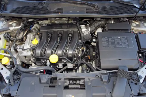 Silnik samochodu Renault Megane 3, z widocznymi przewodami, cewkami zapłonowymi i żółtymi korkami.