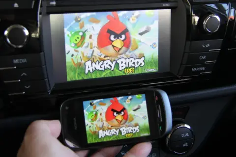 Gra Angry Birds na ekranie telefonu i samochodowego systemu multimedialnego. Działa jako mirror link, przenosząc rozgrywkę na większy ekran.