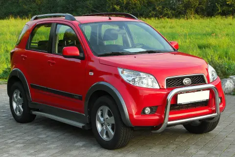 Czerwony Daihatsu Terios z metalowym orurowaniem z przodu, gotowy na przygodę.