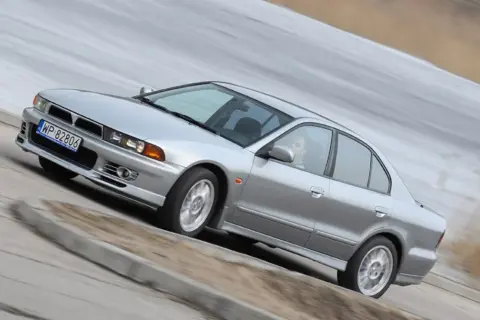 Srebrny Mitsubishi Galant z gracją pokonuje zakręt.