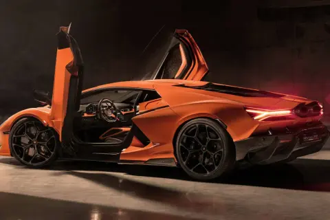 Pomarańczowe Lamborghini Revuelto z otwartymi drzwiami i podniesionymi maskami, widok z boku i tyłu.