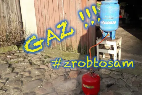 Gaz! Jak zakręcić zawór butli LPG? Czerwona butla z gazem i niebieska butla na stołku, połączone wężem. #zróbtosam