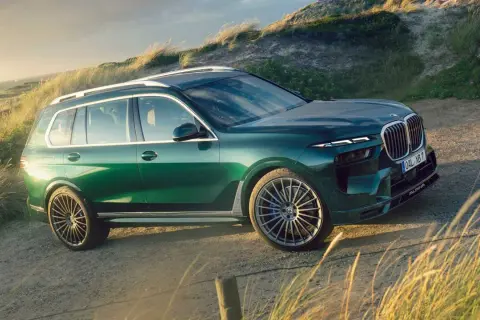 Zielony Alpina XB7 na tle wydm i morza. Luksusowy SUV gotowy na przygodę.