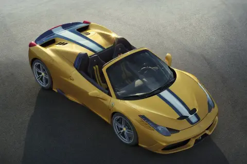 Żółte Ferrari 458 Spider z niebiesko-białymi pasami na masce i tyle, gotowe do jazdy po torze.