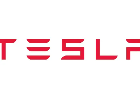Czerwony napis TESLA na białym tle. Taki znaczek ma Tesla, symbol innowacji i przyszłości motoryzacji.