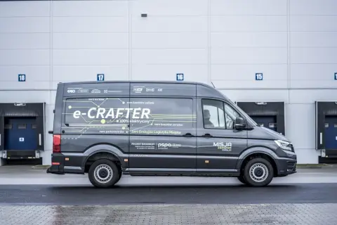 Szary e-Crafter z napisem "Misja Zerowa Emisja" pokazuje, ile kosztuje przerobienie samochodu na elektryczny, oferując zero kosztów paliwa i serwisu.