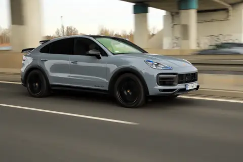 Szary Porsche Cayenne Turbo GT pędzi autostradą, zostawiając za sobą rozmyte tło.