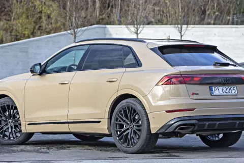 Beżowe Audi RSQ8 z czarnymi felgami stoi na zewnątrz.