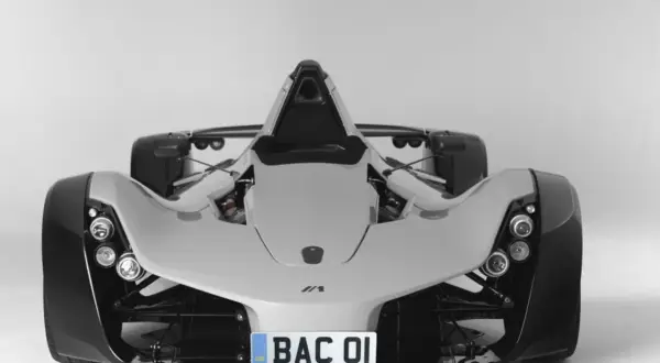 Biały, sportowy samochód BAC Mono z widocznym silnikiem i tablicą rejestracyjną "BAC 01".
