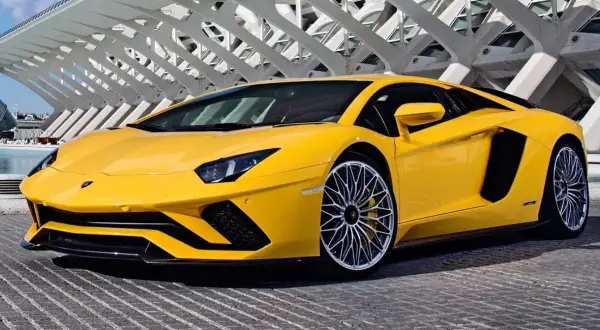 Żółty Lamborghini Aventador z futurystyczną architekturą w tle.