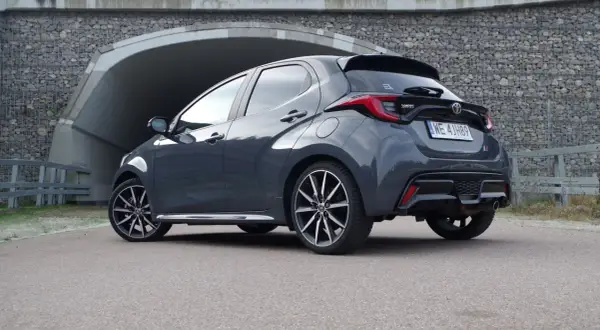 Szary Toyota Yaris Hybrid stoi przed tunelem.