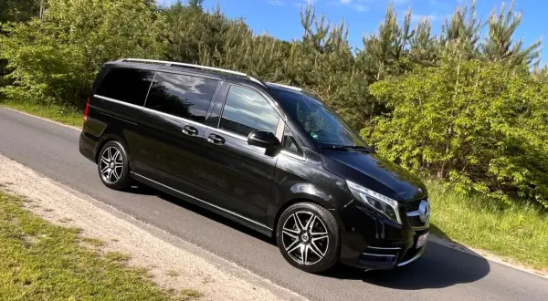 Czarny Mercedes-Benz V-klasa na drodze wśród zieleni.