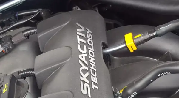 Silnik SKYACTIV TECHNOLOGY, jeden z najlepszych silników benzynowych, z widocznymi przewodami i złączkami.