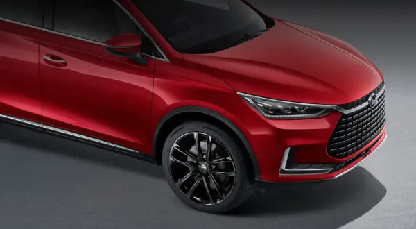 Czerwony BYD Tang błyszczy na ciemnym tle, prezentując eleganckie linie i sportowe felgi.