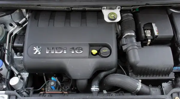 Silnik Peugeot 307 2.0 HDI 16V. Widoczny czarny plastikowy kolektor, przewody i akumulator.