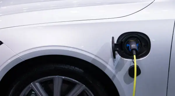 Ładowanie samochodu elektrycznego: wtyczka w gnieździe, pytanie brzmi, jak długo trwa ładowanie.