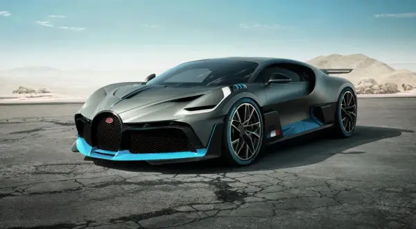 Szary Bugatti Divo z niebieskimi akcentami na pustynnej drodze.