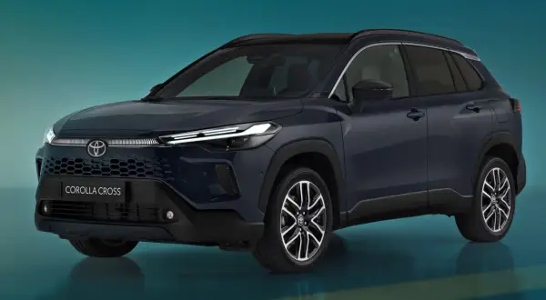 Nowa Toyota Corolla Cross w ciemnogranatowym kolorze, z nowoczesnym grillem i reflektorami LED, prezentuje się dynamicznie na tle turkusowego tła.
