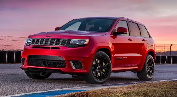 Czerwony Jeep Grand Cherokee Trackhawk na torze wyścigowym, gotowy do akcji.