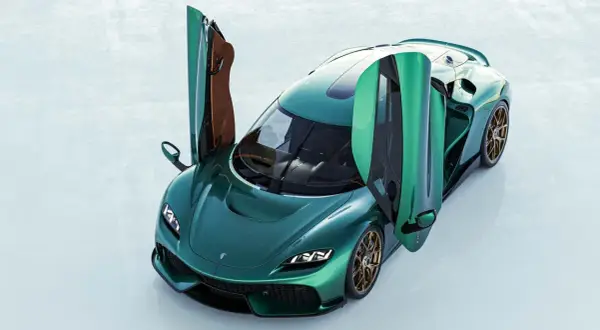 Zielony Koenigsegg Gemera z otwartymi drzwiami, prezentujący swoje luksusowe wnętrze i sportowy design.