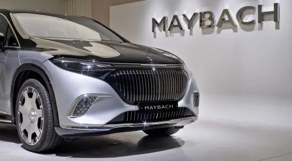 Przód luksusowego samochodu Maybach w kolorze srebrno-czarnym, z logo marki na masce i na grillu.