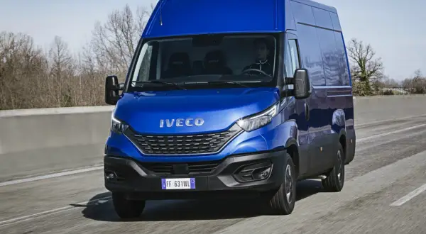 Niebieski Iveco Daily w ruchu drogowym. Kierowca za kierownicą. Pytanie: iveco daily ile oleju do silnika?