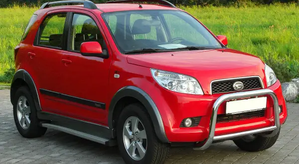 Czerwony Daihatsu Terios z metalowym orurowaniem z przodu, gotowy na przygodę.