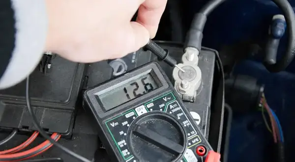 Sprawdzanie akumulatora za pomocą multimetru. Wynik 12.6V pokazuje, że jest w dobrym stanie.