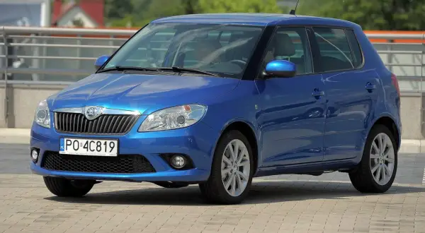 Niebieska Skoda Fabia 2025 z polskimi tablicami PO 4C819 zaparkowana na placu.