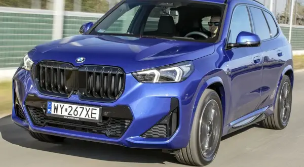 Niebieskie BMW X1 w ruchu. Zwróć uwagę na jego dynamiczne linie i kompaktowe bmw x1 wymiary, idealne do miasta.