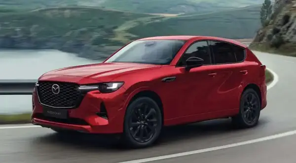 Czerwona Mazda CX-60 3.3 diesel pokonuje zakręt na malowniczej drodze.