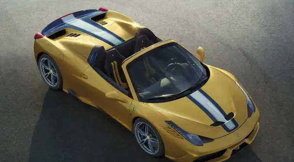 Żółte Ferrari 458 Spider z niebiesko-białymi pasami na masce i tyle, gotowe do jazdy po torze.