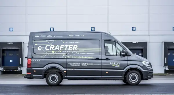 Szary e-Crafter z napisem "Misja Zerowa Emisja" pokazuje, ile kosztuje przerobienie samochodu na elektryczny, oferując zero kosztów paliwa i serwisu.