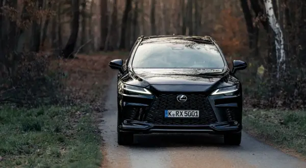 Czarny Lexus RX 350 na leśnej drodze.