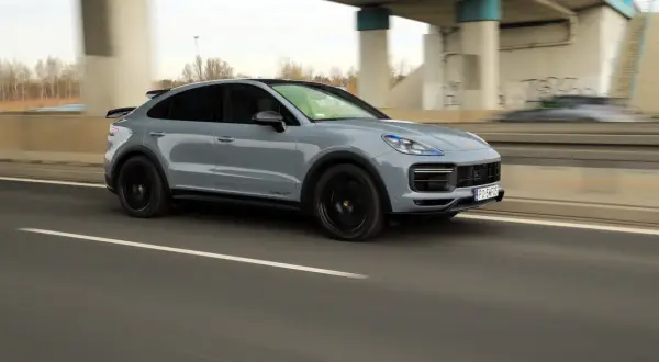 Szary Porsche Cayenne Turbo GT pędzi autostradą, zostawiając za sobą rozmyte tło.