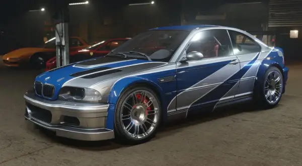 Ikoniczne BMW M3 GTR w niebiesko-srebrnym malowaniu, gotowe do wyścigu.