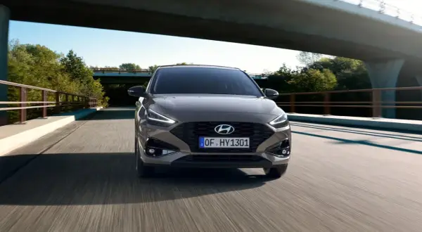 Szary Hyundai i30 1.4 benzyna jedzie pod mostem.