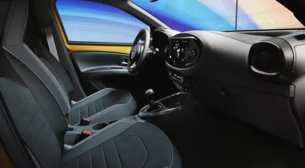 Wnętrze samochodu z nowoczesnymi fotelami i ekranem dotykowym. System keyless go ułatwia wsiadanie i ruszanie.