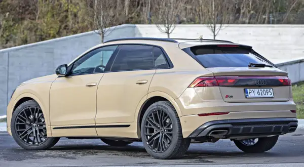 Beżowe Audi RSQ8 z czarnymi felgami stoi na zewnątrz.