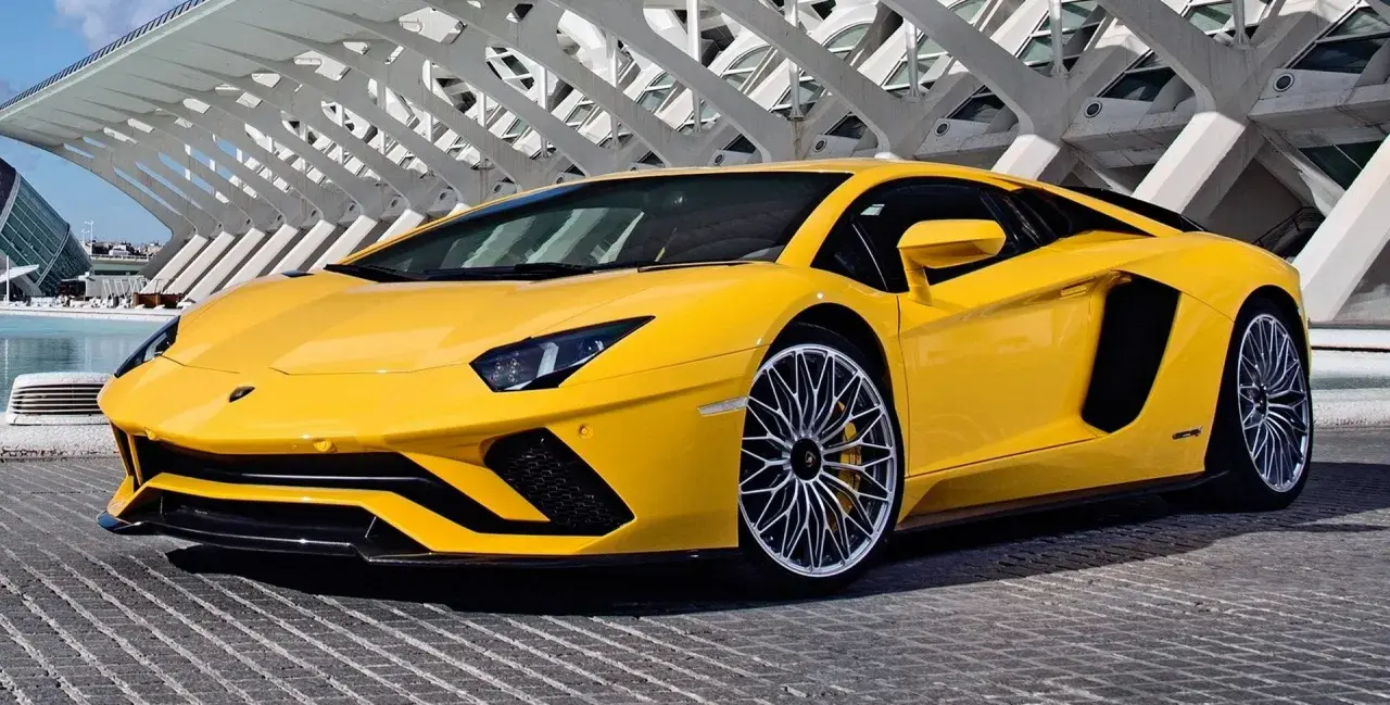 Żółty Lamborghini Aventador z futurystyczną architekturą w tle.