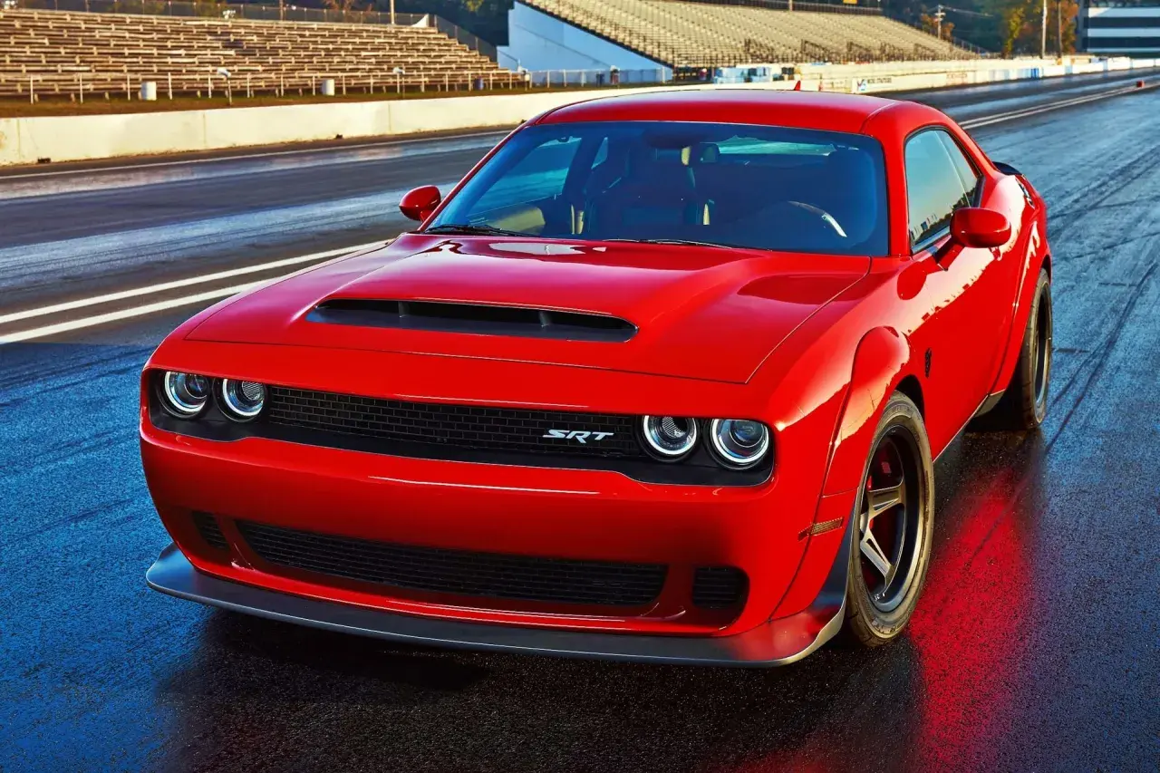 Czerwony Dodge Challenger 5.7 Hemi na torze wyścigowym, gotowy do startu.