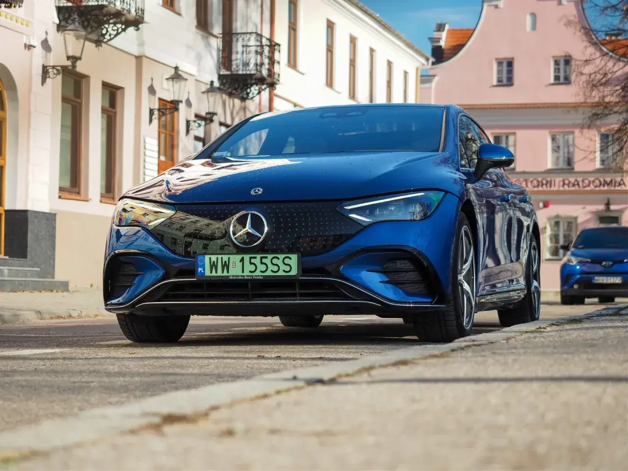 Elegancki, granatowy Mercedes EQE na ulicy.