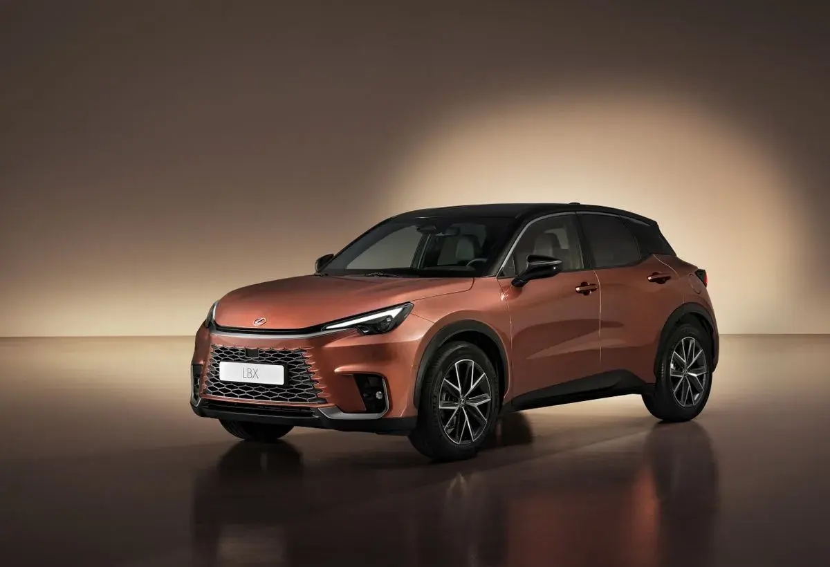 Pomarańczowy Lexus LBX z czarnym dachem, prezentujący swoje kompaktowe wymiary.