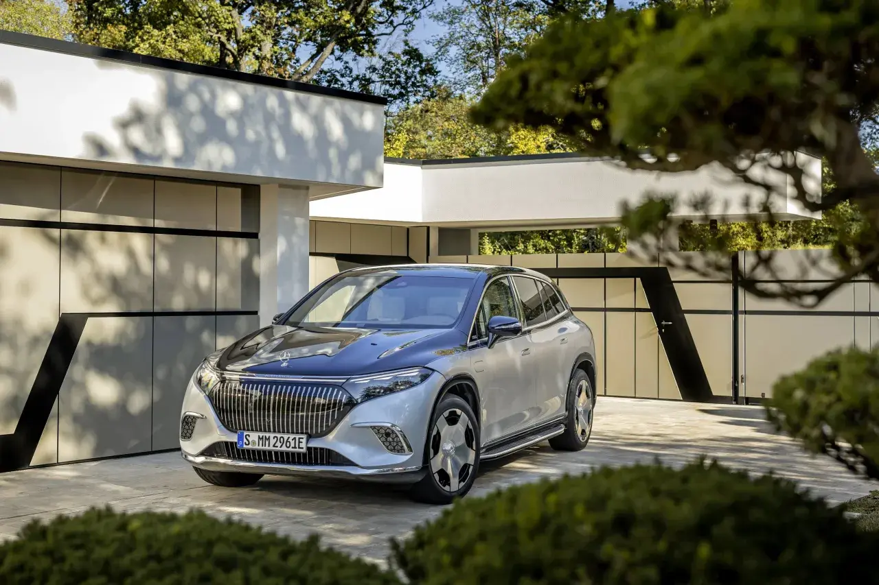 Elegancki Maybach SUV w kolorze srebrno-czarnym zaparkowany przed nowoczesnym domem.