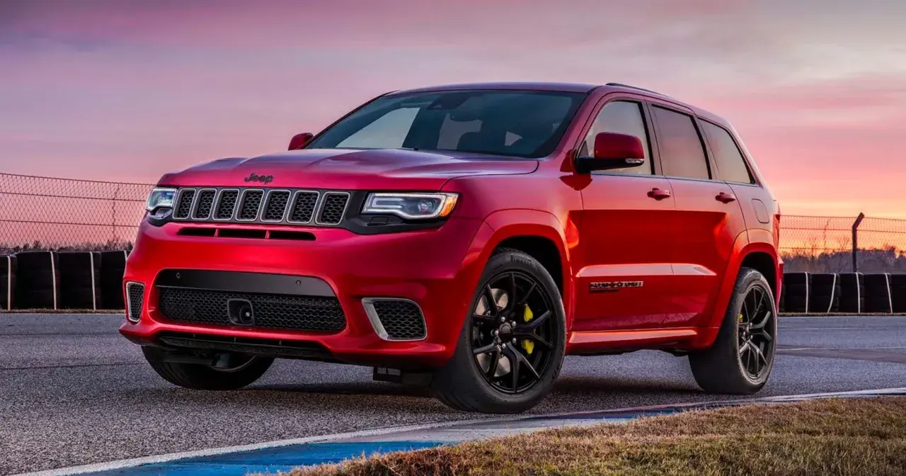Czerwony Jeep Grand Cherokee Trackhawk na torze wyścigowym, gotowy do akcji.