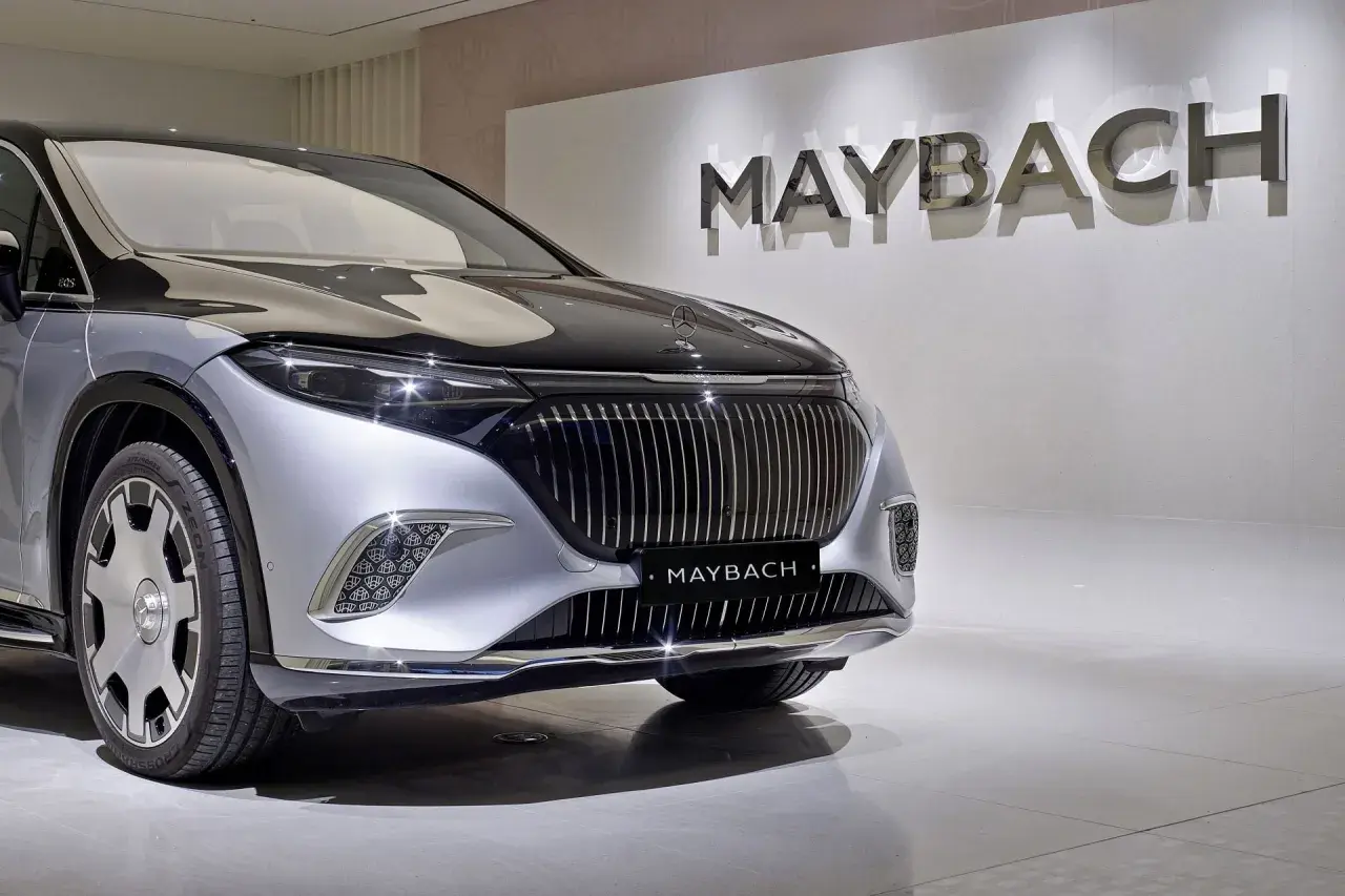 Przód luksusowego samochodu Maybach w kolorze srebrno-czarnym, z logo marki na masce i na grillu.
