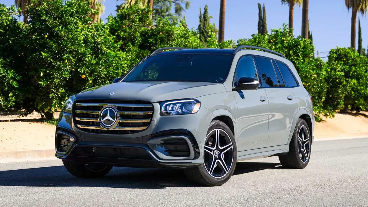 Szary Mercedes-Benz GLS na tle zieleni. Elegancki SUV z charakterystycznym grillem i felgami.