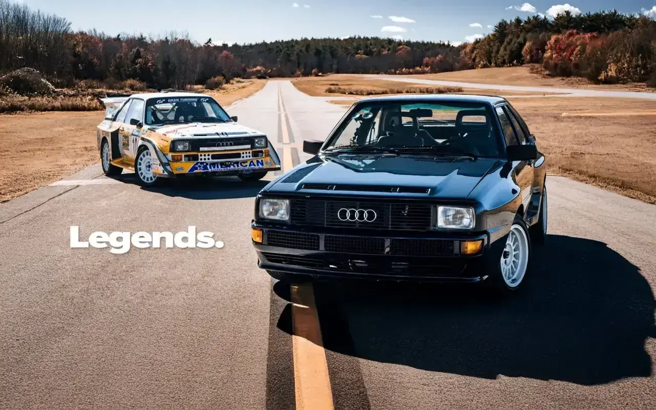 Dwa kultowe Audi quattro S1 na drodze. Jeden w barwach rajdowych, drugi czarny, lśniący.