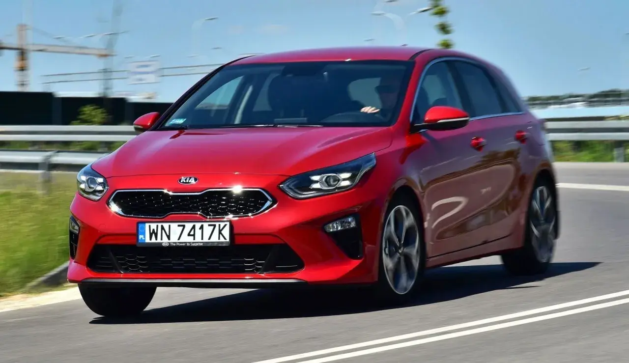 Czerwony Kia Ceed 1.4 benzyna w ruchu drogowym. Elegancki hatchback z dynamicznym wyglądem.