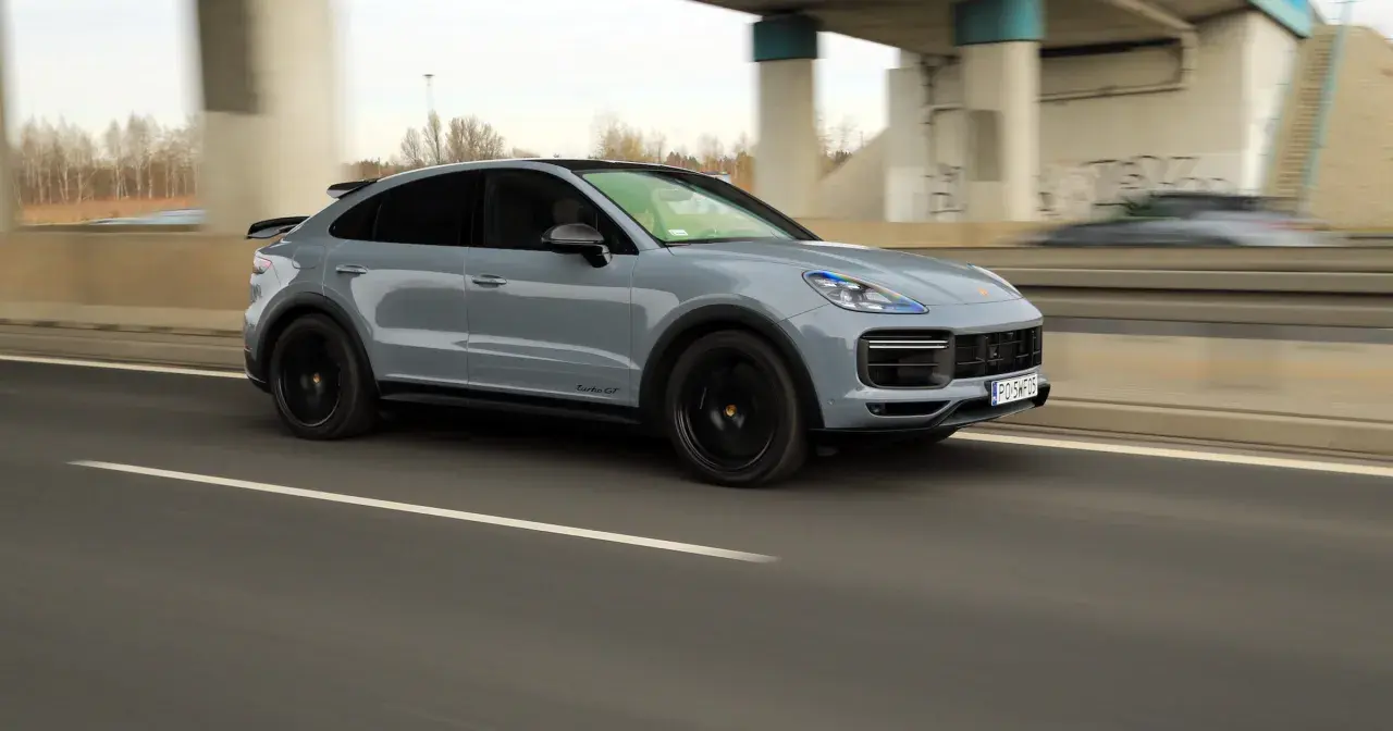 Szary Porsche Cayenne Turbo GT pędzi autostradą, zostawiając za sobą rozmyte tło.